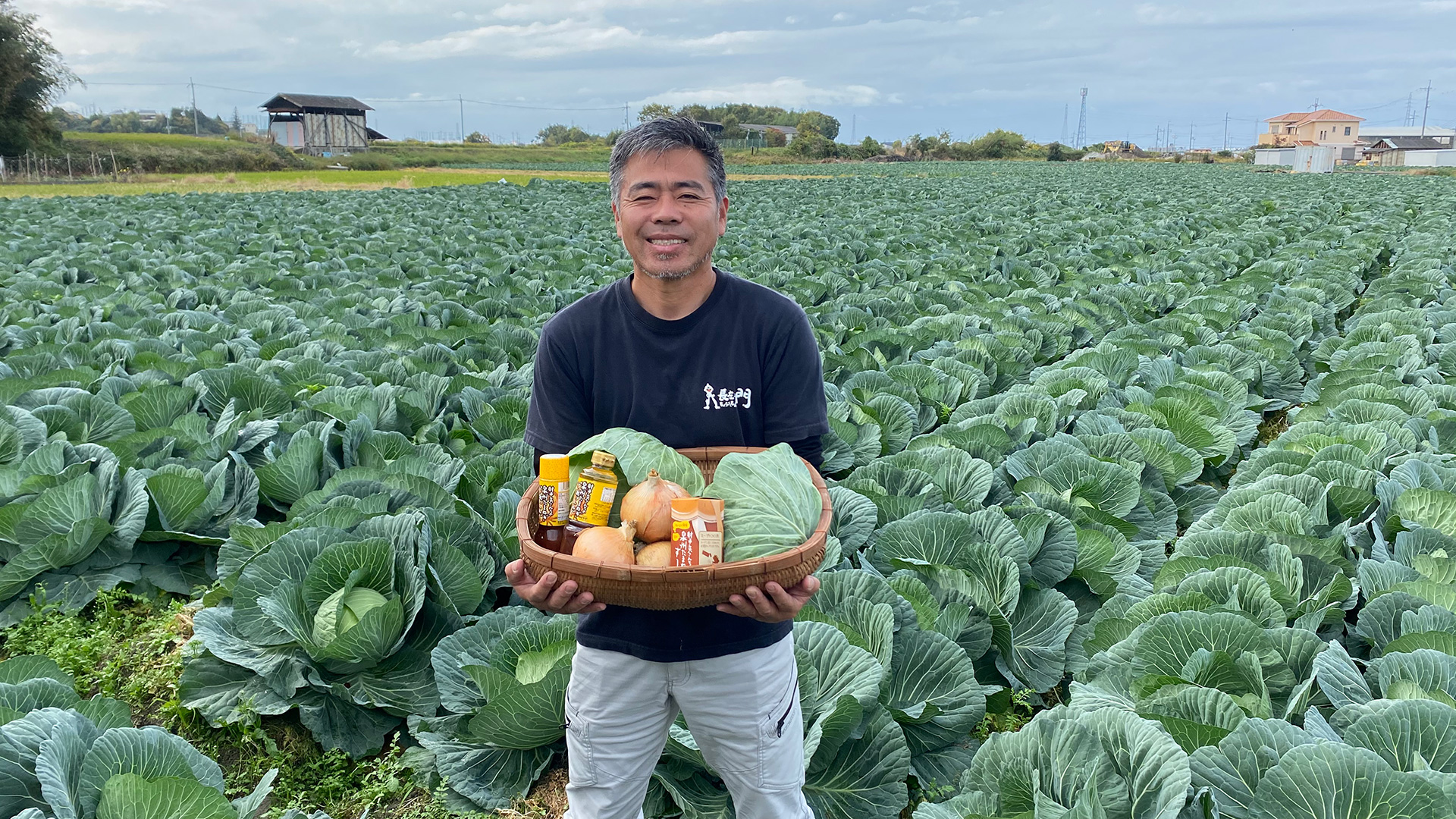 キャベツ畑で地上産品を抱える男性